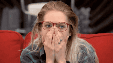 woman looks annoyed and holds her hands over her mouth