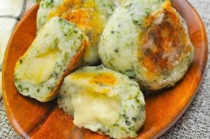木の皿に乗ったチーズ入りのポテト団子が数個あります。