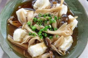 切り餅のきのこあんかけが乗ったお皿。刻みネギがトッピングされています。