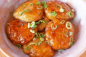 器に盛られた豆腐とれんこんで作られた餅5つ。上にネギが散らされている。