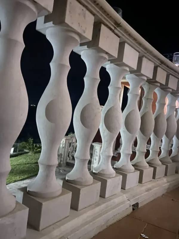 Stone balusters on a terrace with a nighttime background visible through them