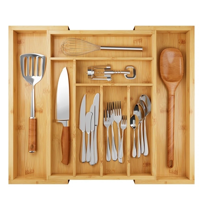 Bamboo utensil drawer organizer holding various kitchen tools and cutlery, including knives, forks, spoons, and gadgets, ideal for organized storage