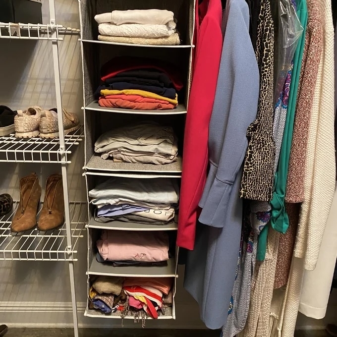 Organized closet with folded clothes, hanging coats, and shoes on racks