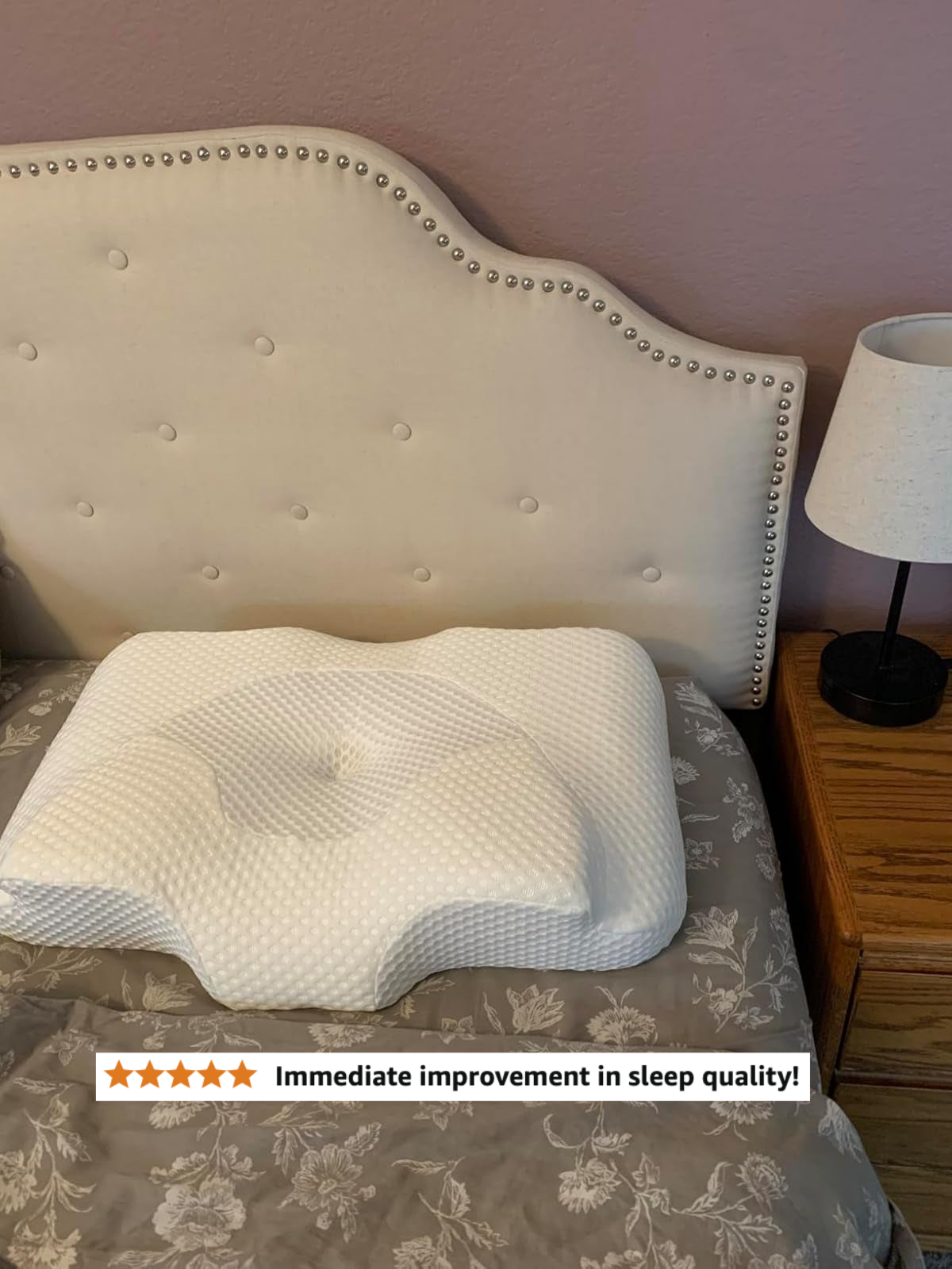 Ergonomic pillow on a decorated bed near a nightstand with a lamp, showcasing bedroom essentials for comfort and support