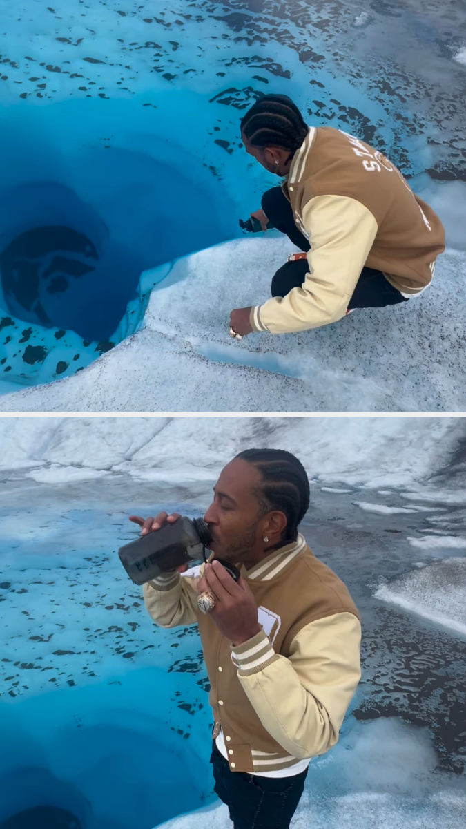 Ludacris with braided hair, in a varsity jacket, kneels to drink water from a glacier using a bottle