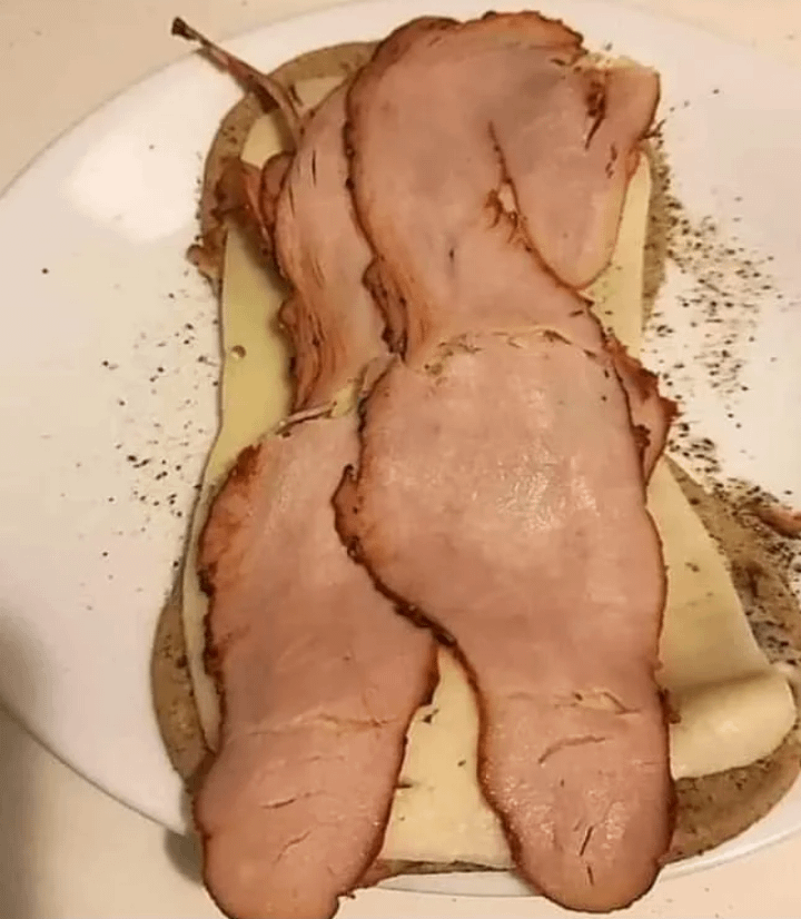 Slices of deli meat on sliced bread and cheese, with the arrangement resembling a woman's torso
