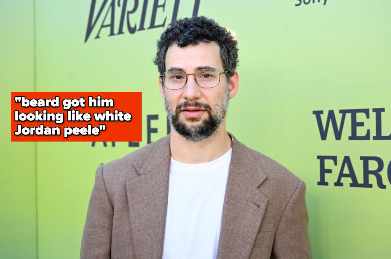 Person with glasses and beard in a brown blazer on a red carpet, text overlay reads: "beard got him looking like white Jordan Peele."