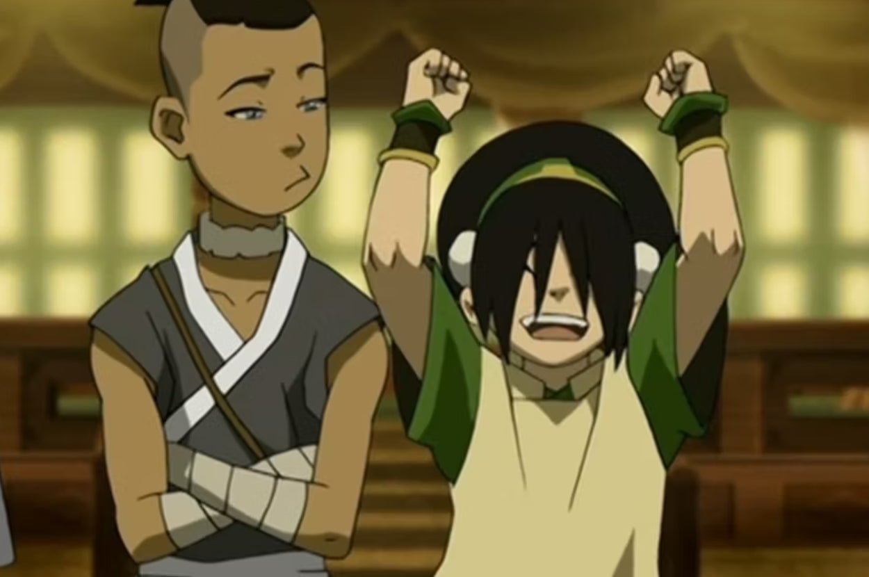 A young animated girl excitedly raises her arms, while a boy beside her looks unimpressed, arms crossed. They are characters from an animated series