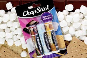 ChapStick S'mores Collection featuring Milk Chocolate, Marshmallow, and Graham Cracker flavors, with marshmallows and chocolate in the background