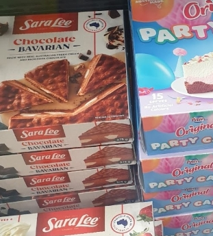 Freezer conception displaying assorted cakes, including Sara Lee Bavarian slices, strawberry coulis cheesecake, and Peter's Original Party Cake