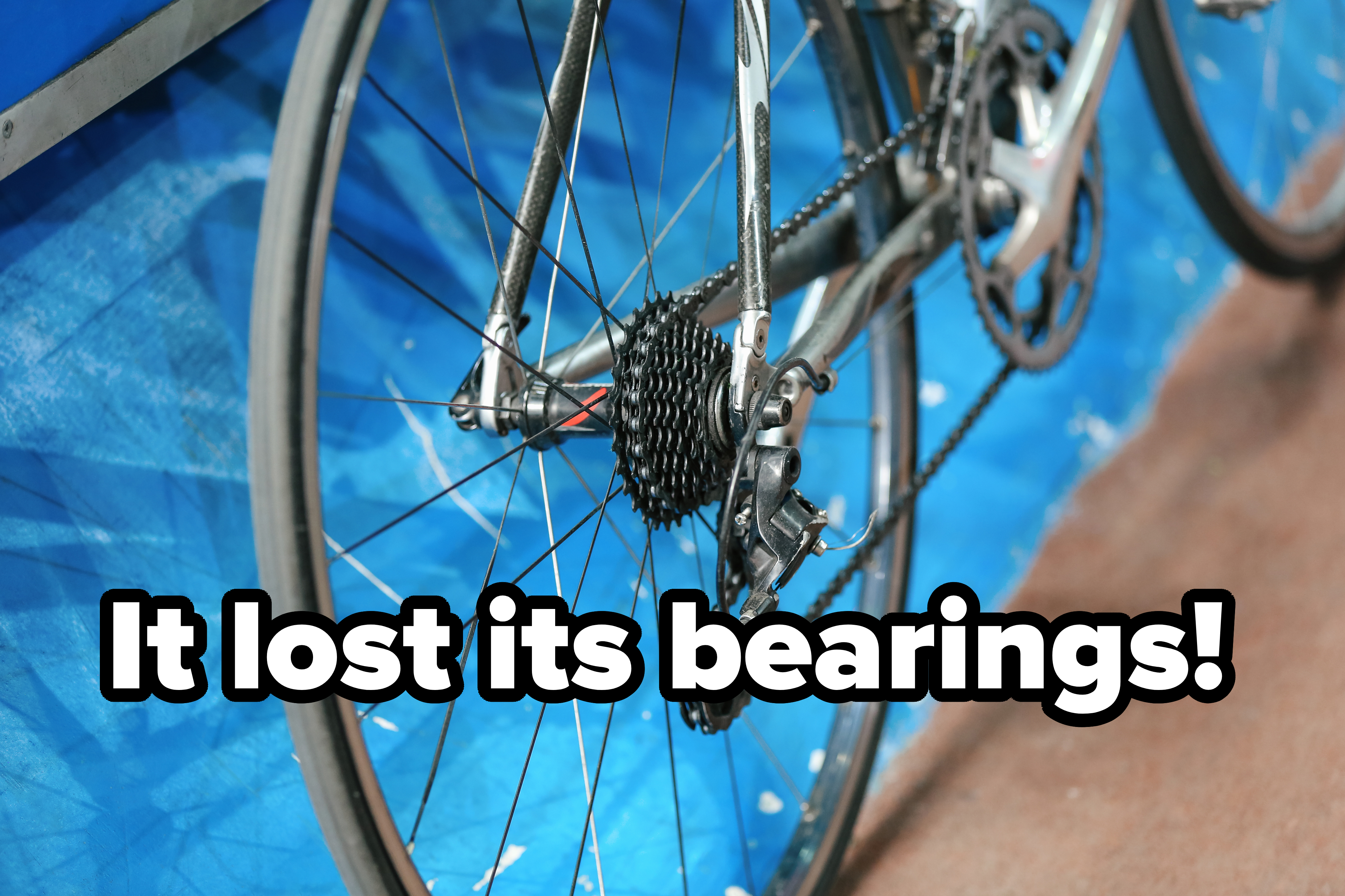 Close-up of a bicycle&#x27;s rear wheel and gears against a blurred background