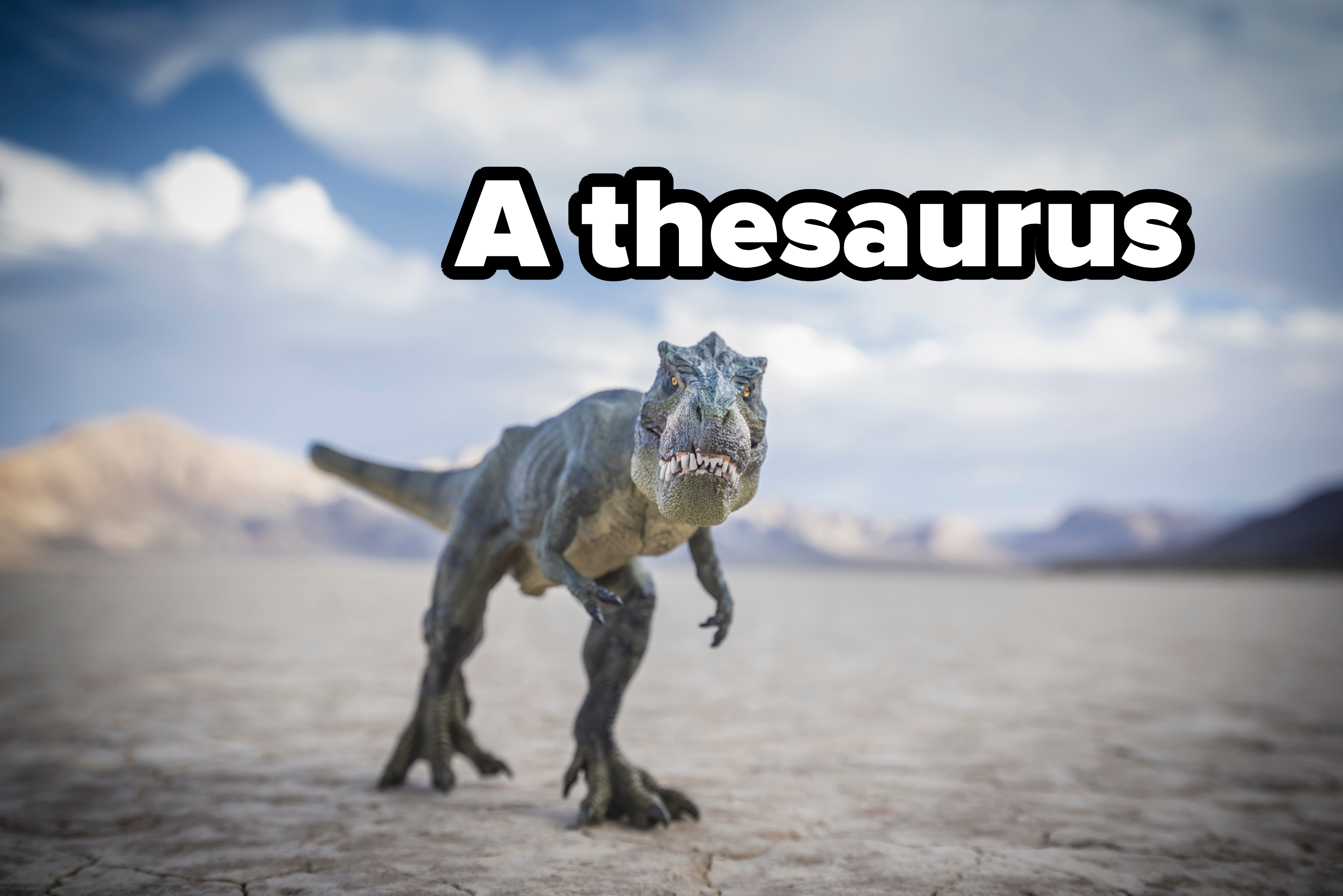 A realistic dinosaur model, resembling a T. rex, stands in a barren desert landscape under a cloudy sky