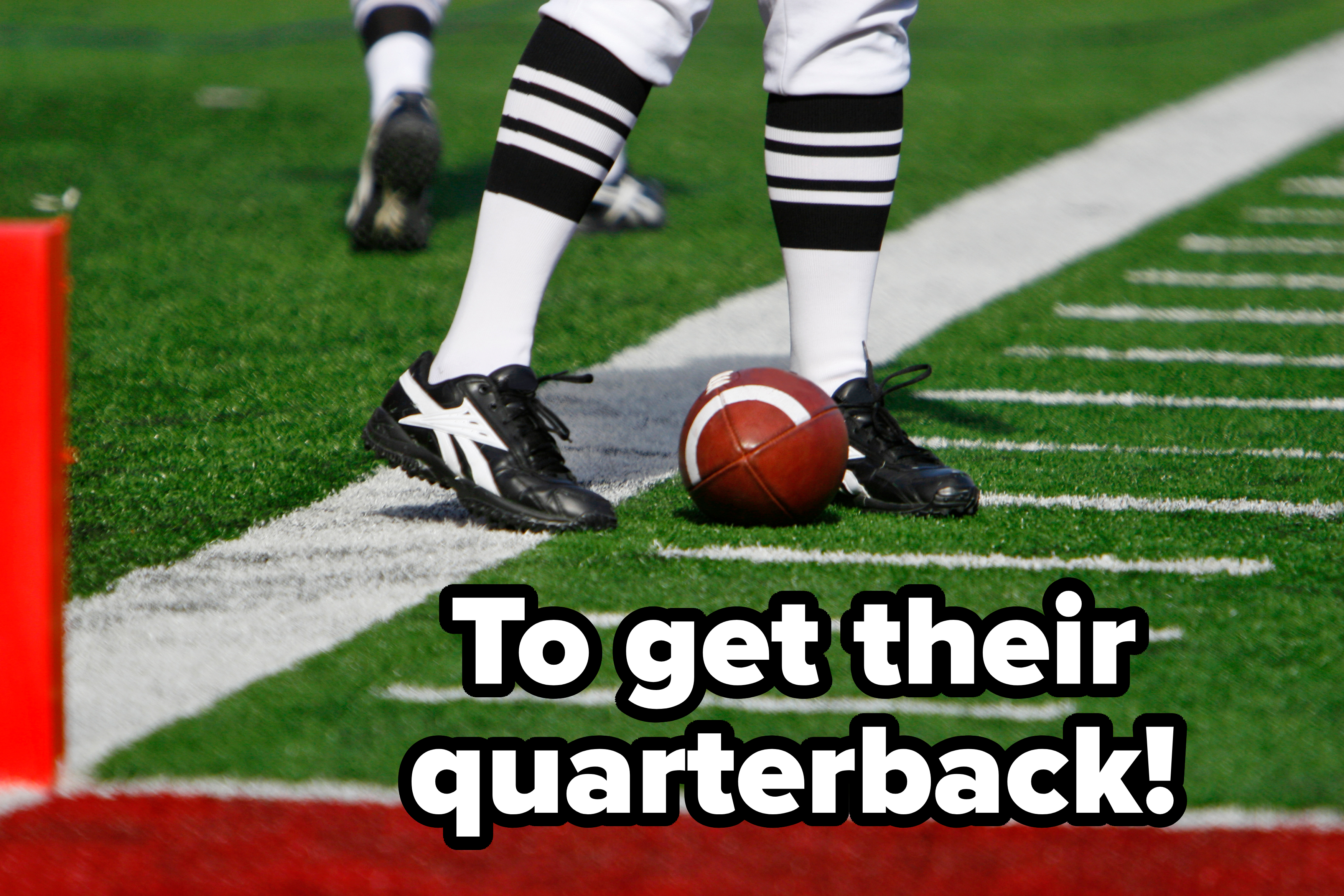 Football player in striped socks stands near the sideline with a football on the ground