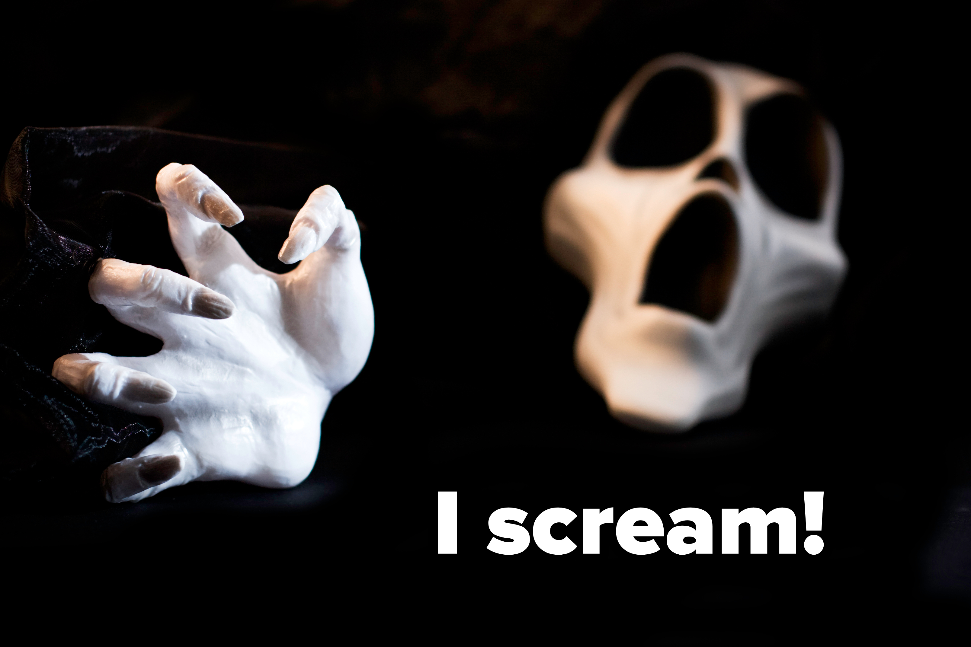 A white ghost mask and a white claw-like hand reach dramatically out against a dark background