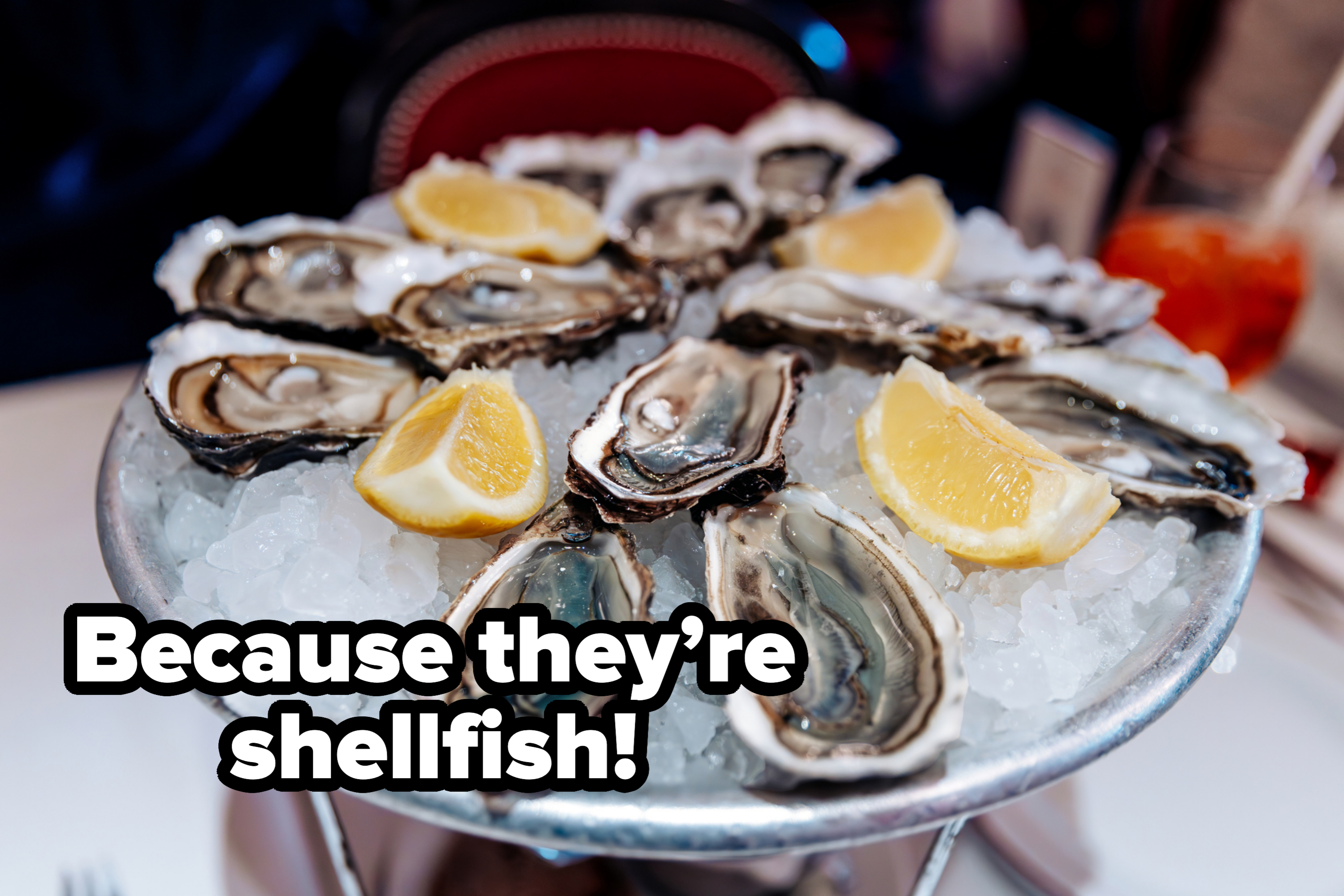 Oysters on ice with lemon wedges, served on a platter