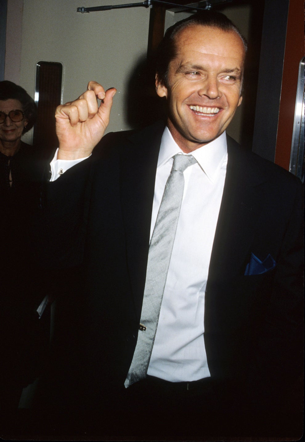 24 Bizarre Celeb Facts That Sound Fake, But Are 100% True 24 Man in a suit and tie smiling and gesturing, standing at an event