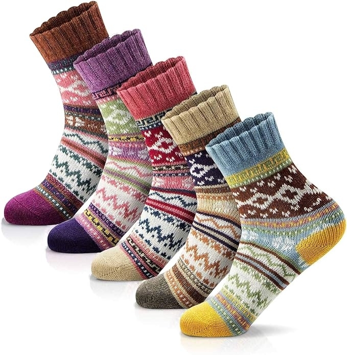 Five pairs of knitted socks in various patterns and designs, neatly arranged in a row