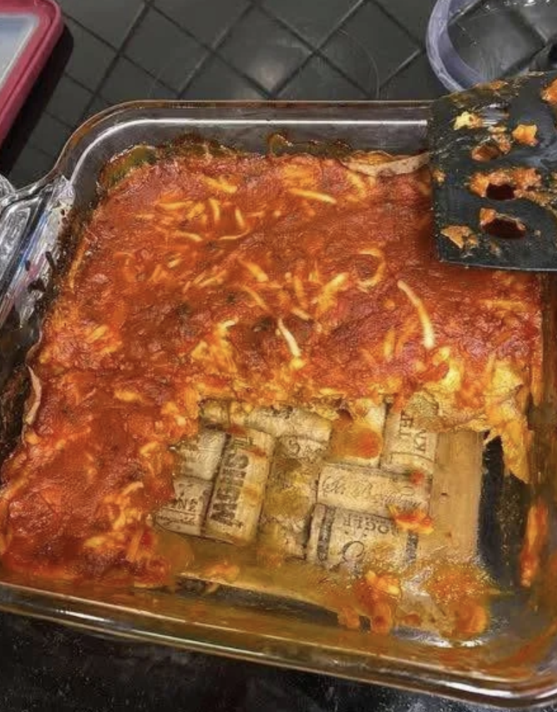 Lasagna in a glass dish with visible layers, but instead of pasta, it contains several U.S. dollar bills