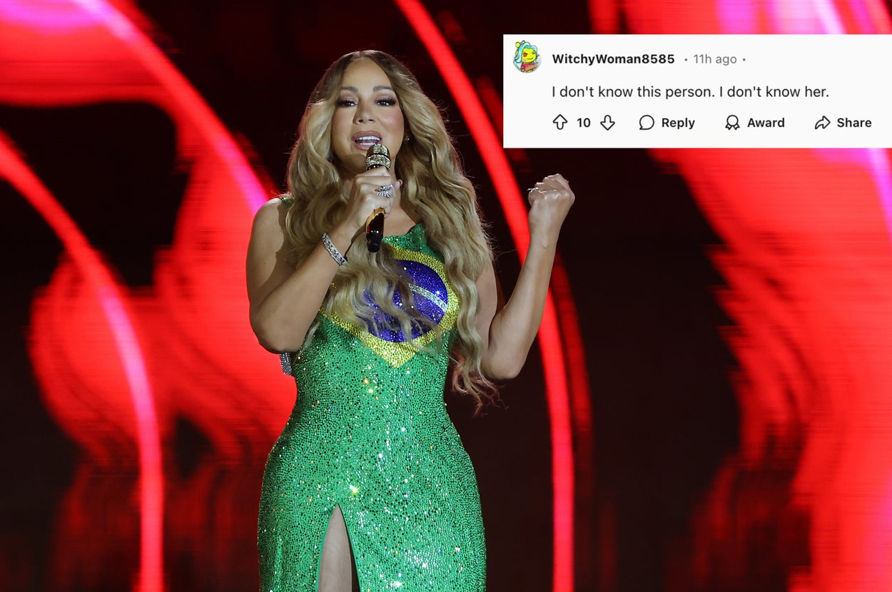 Mariah Carey performing on stage in a sparkling dress with a high slit, featuring a prominent design on the front