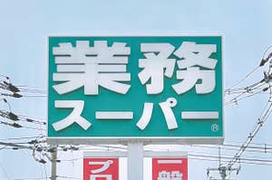 「業務スーパー」の看板。電線が背景に見える。