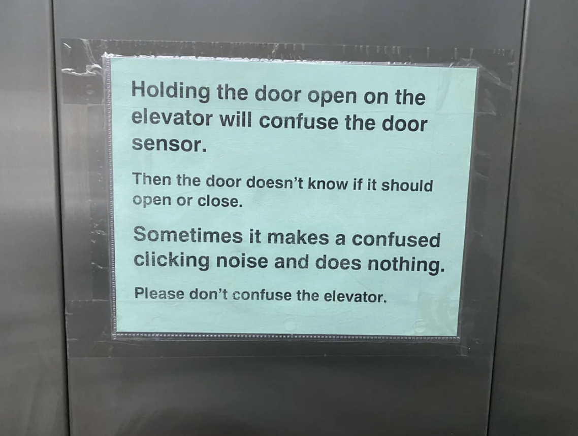 Sign on elevator explains that holding the door open confuses the sensor, causing clicking sounds. It advises not to confuse the elevator