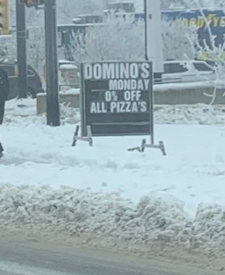 Sign in snow: "Domino's Monday 0% off all pizza's."