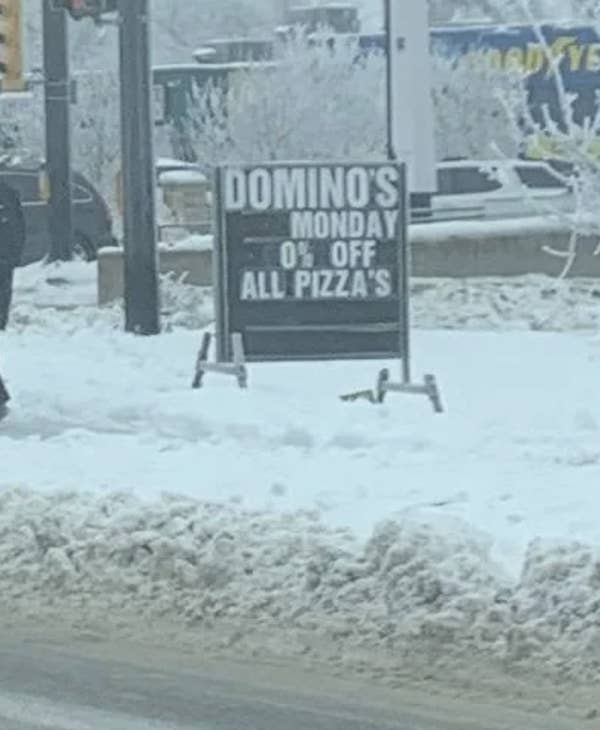 Sign in snow: &quot;Domino&#x27;s Monday 0% off all pizza&#x27;s.&quot;