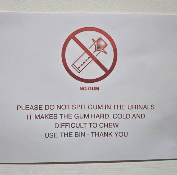Sign with red crossed-out gum graphic. Text: &quot;Do not spit gum in urinals. Gum becomes hard, cold, and difficult to chew. Use bin.&quot;