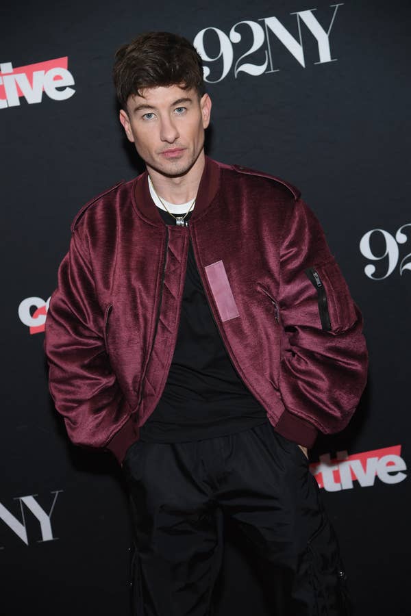 Barry Keoghan in a satin bomber jacket poses at a 92NY event backdrop