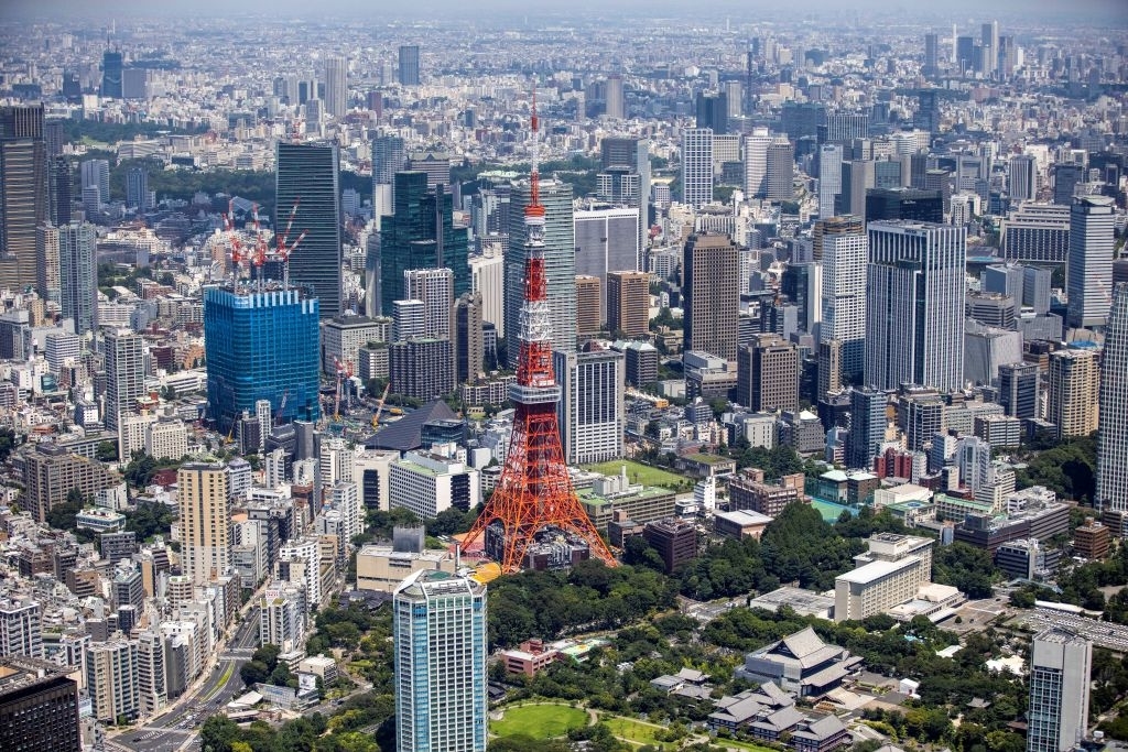 Aerial view of Tokyo cityscape with Tokyo Tower in the center, surrounded by skyscrapers and green spaces