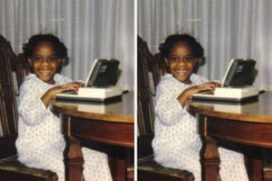 Child smiling while sitting at a table using a typewriter, wearing patterned pajamas