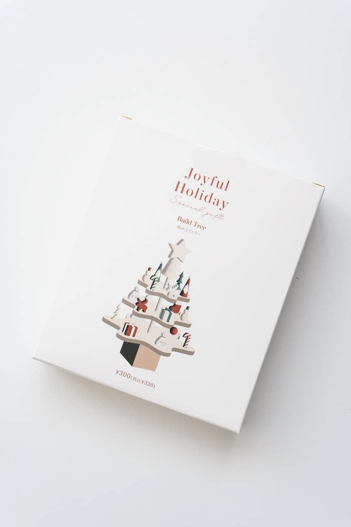 クリスマスツリーのイラストが描かれた「Joyful Holiday」と書かれた白い箱。
