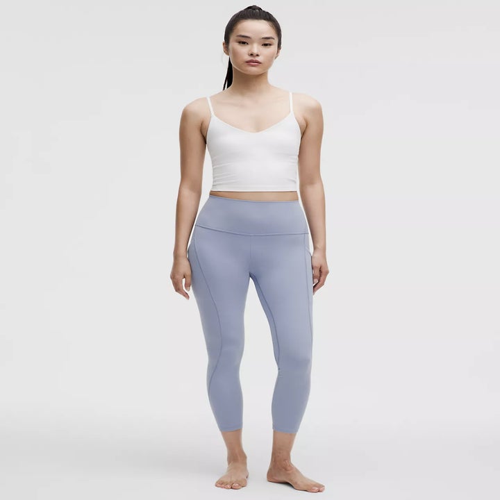 model wearing a white tank top and light blue Align leggings stands in a neutral pose