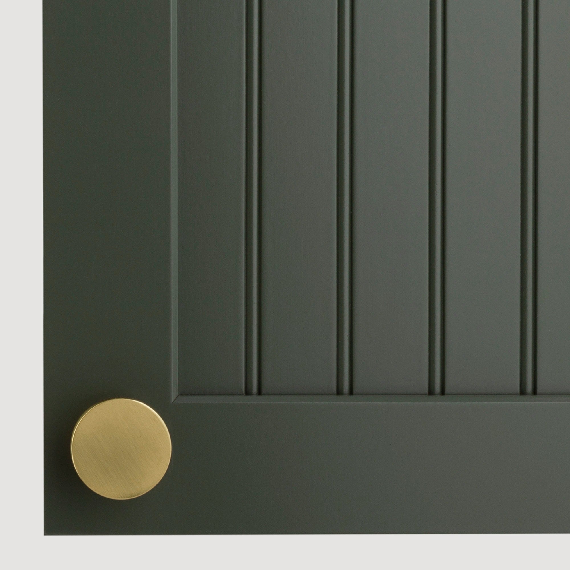 Close-up of a dark vertical paneled cabinet door with a round brass knob, showcasing sophisticated kitchen decor