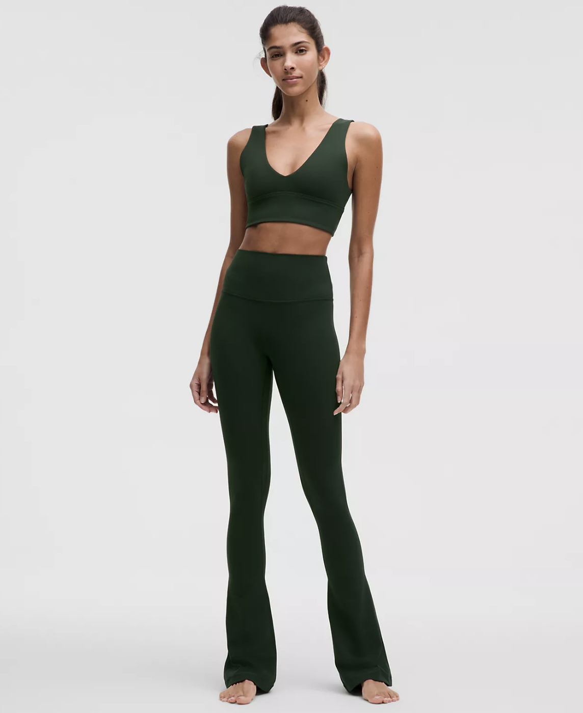 A person models a matching athletic outfit consisting of a sleeveless crop top and flared leggings