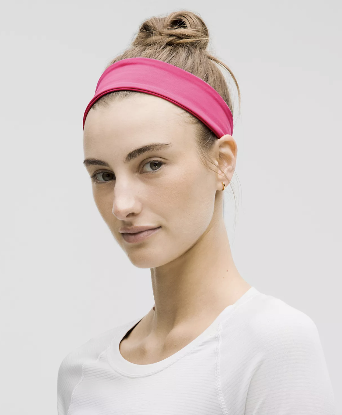 model wearing a bright headband and a casual white top, suitable for fitness or everyday wear