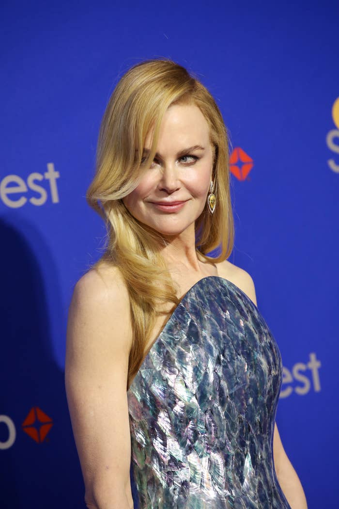 Nicole Kidman posing in an elegant, strapless dress on a blue carpet event