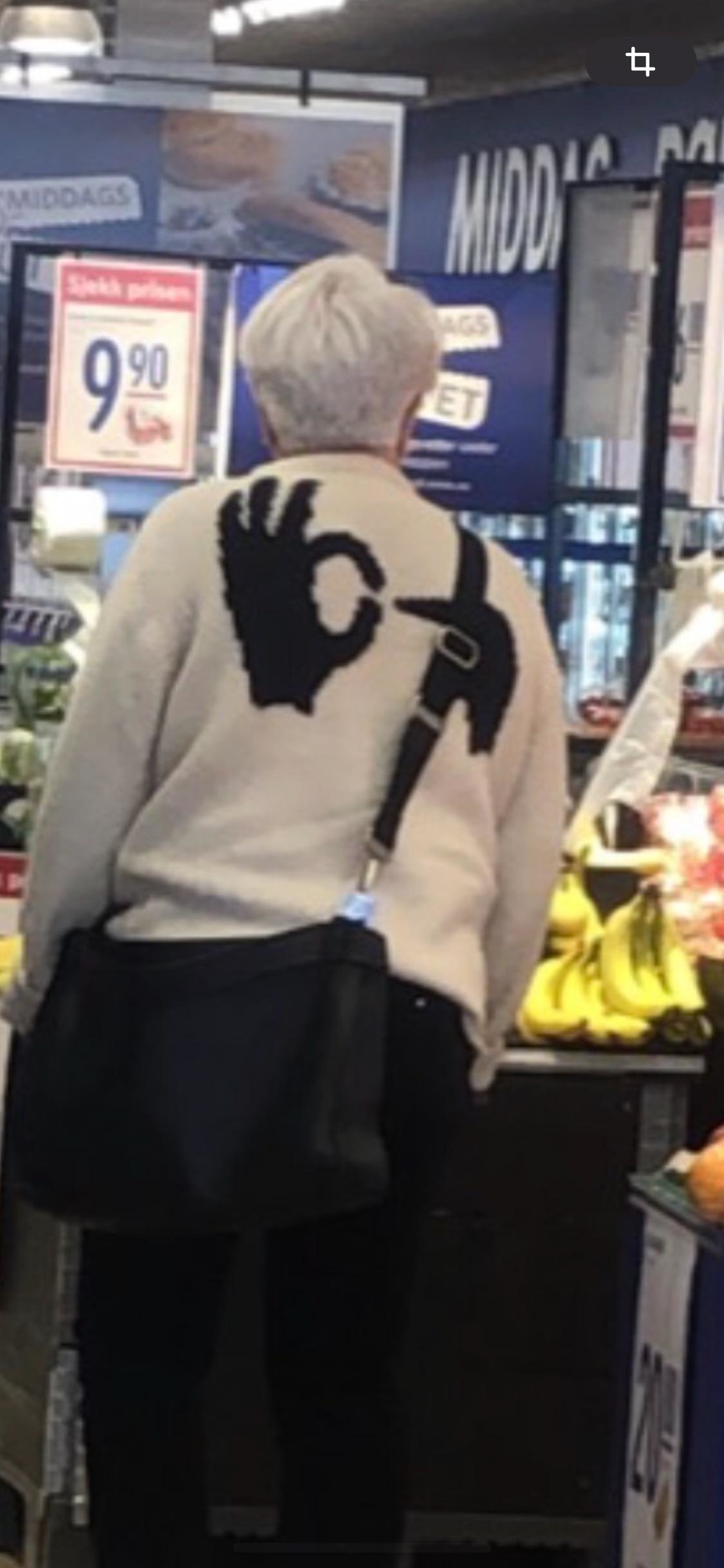 Person with abbreviated  achromatic  hairsbreadth  wearing a sweater with manus  motion  design, buying  successful  a market  store