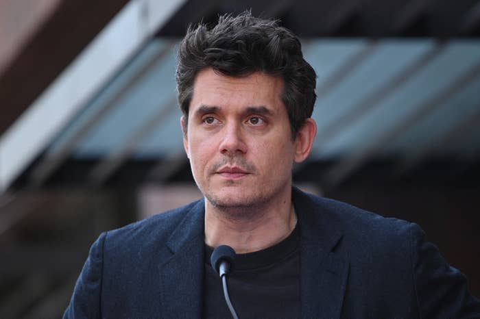 Man in casual blazer speaking at an outdoor event