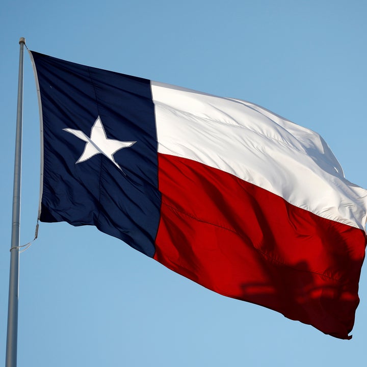 Texas state flag, fluttering in the wind against a clear sky