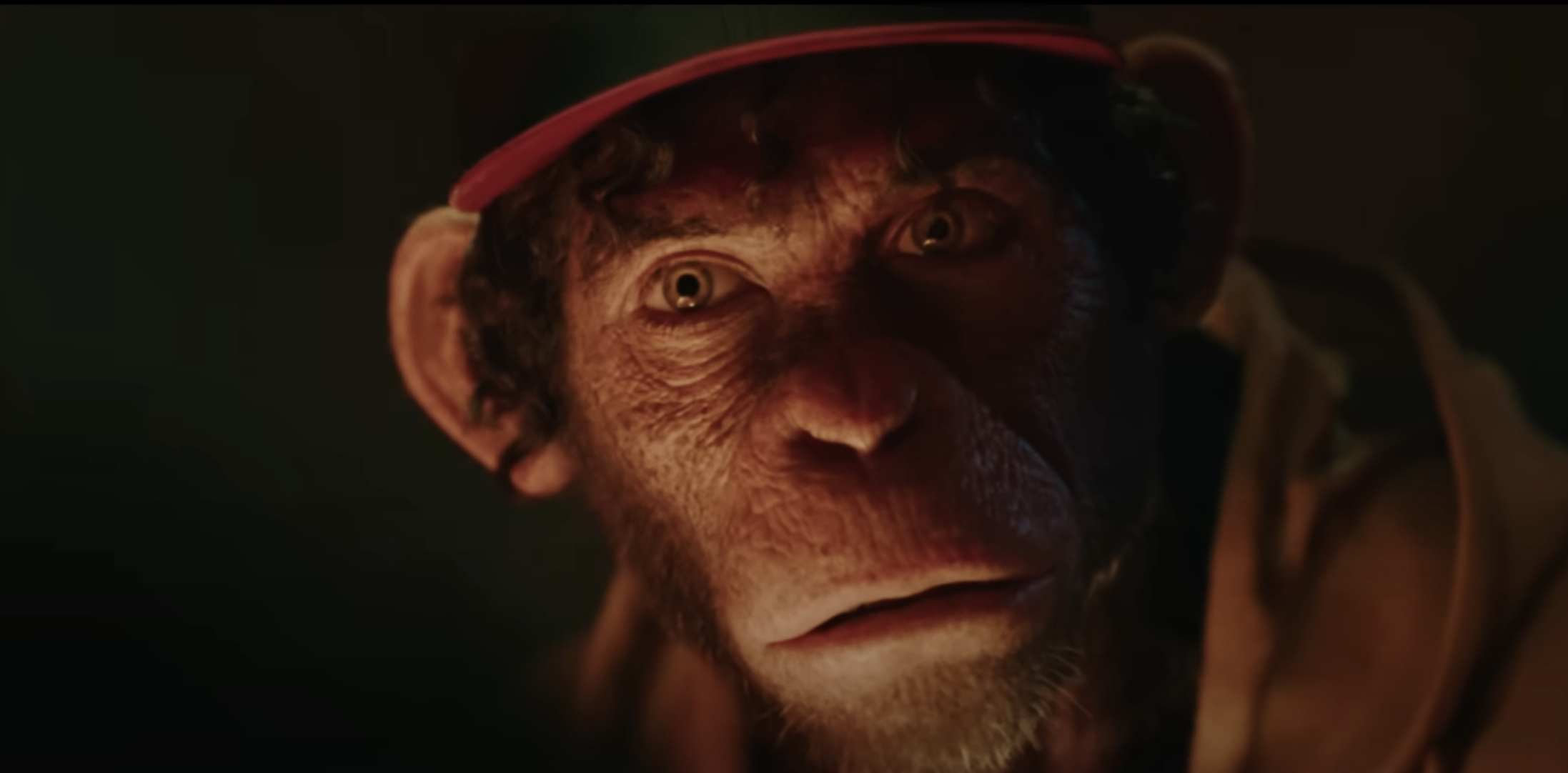 A realistic CGI monkey wearing a baseball cap and hoodie, looking directly at the viewer with a serious expression