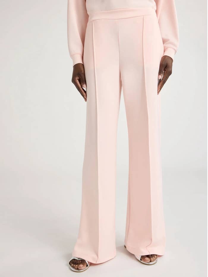 Person wearing stylish wide-leg trousers, portion of a chic outfit, shown successful a buying context