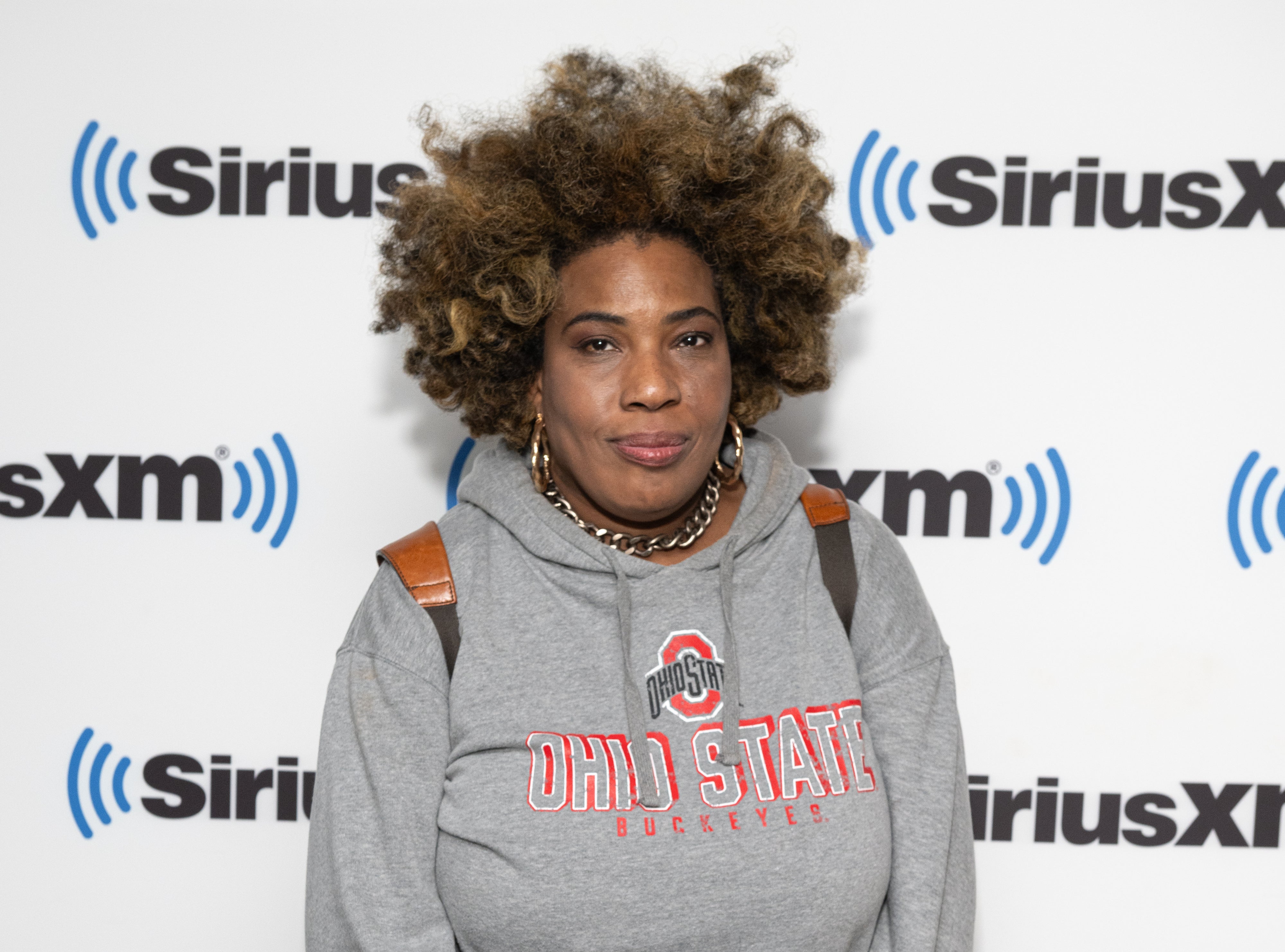 Person with curly hair in an Ohio State sweatshirt stands in front of a SiriusXM backdrop