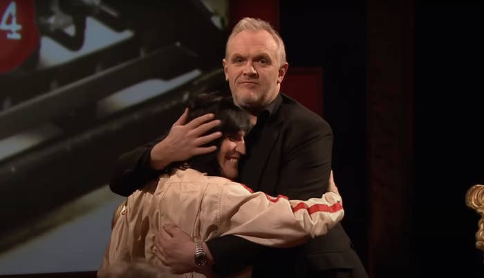 Greg and Noel embracing, with Noel barely reaching Greg's shoulder