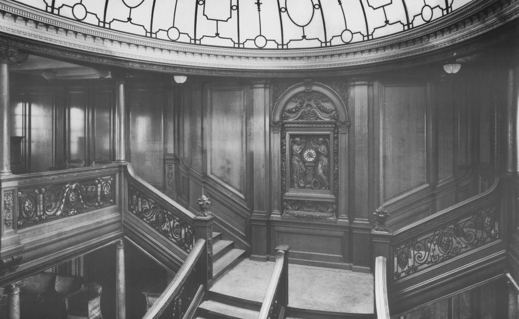Historic expansive  staircase with intricate woodwork and ornate railings nether  a decorative solid  dome ceiling