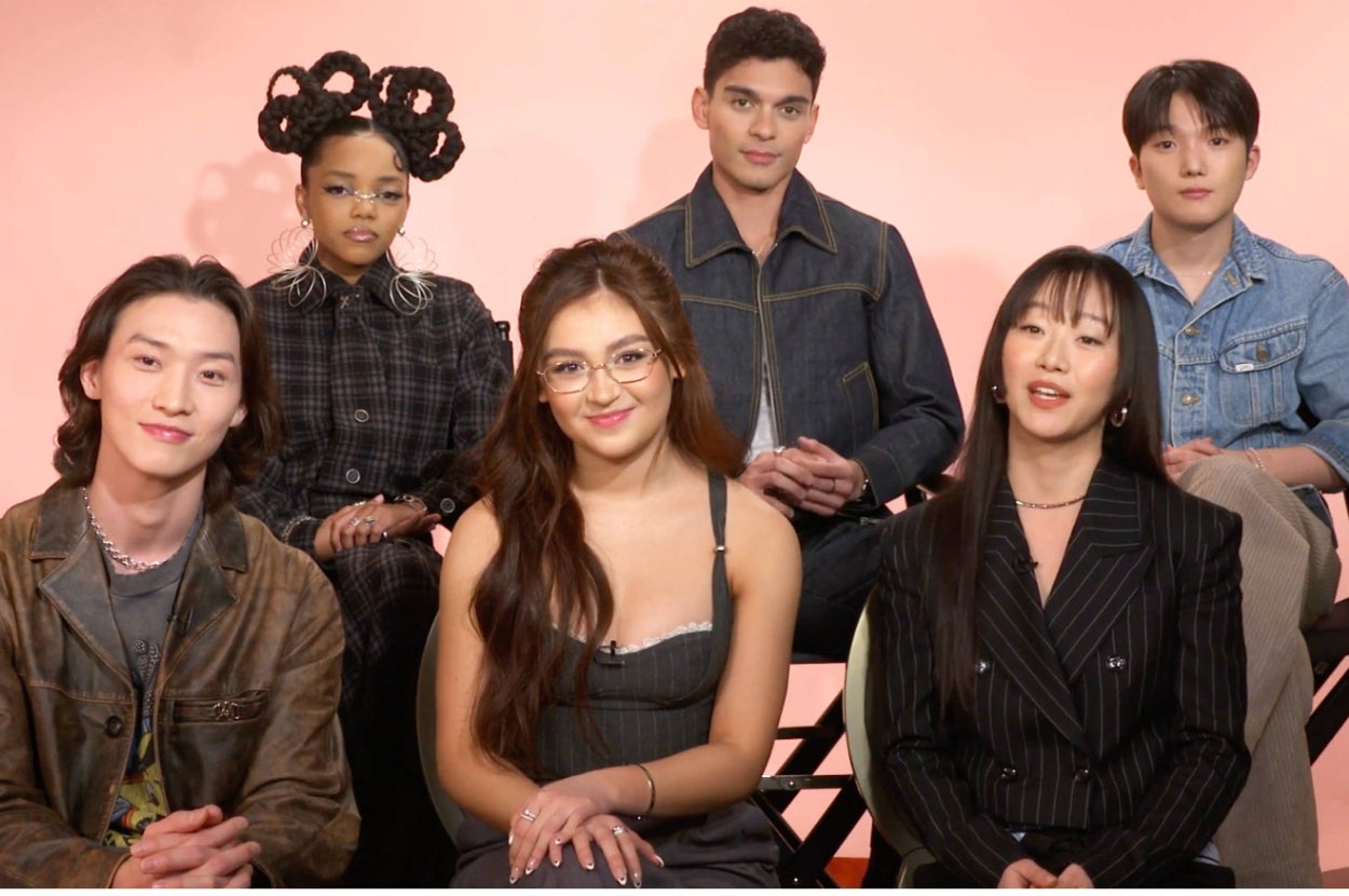 The "XO, Kitty" cast sitting together on a pink backdrop set, taking a quiz