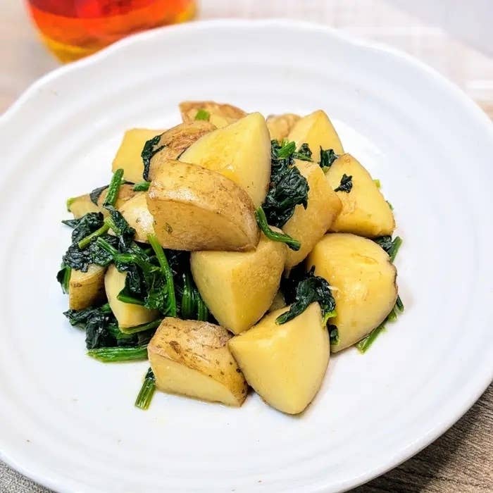 皿に盛られたじゃがいもとほうれん草の炒め物。食欲をそそる盛り付け。