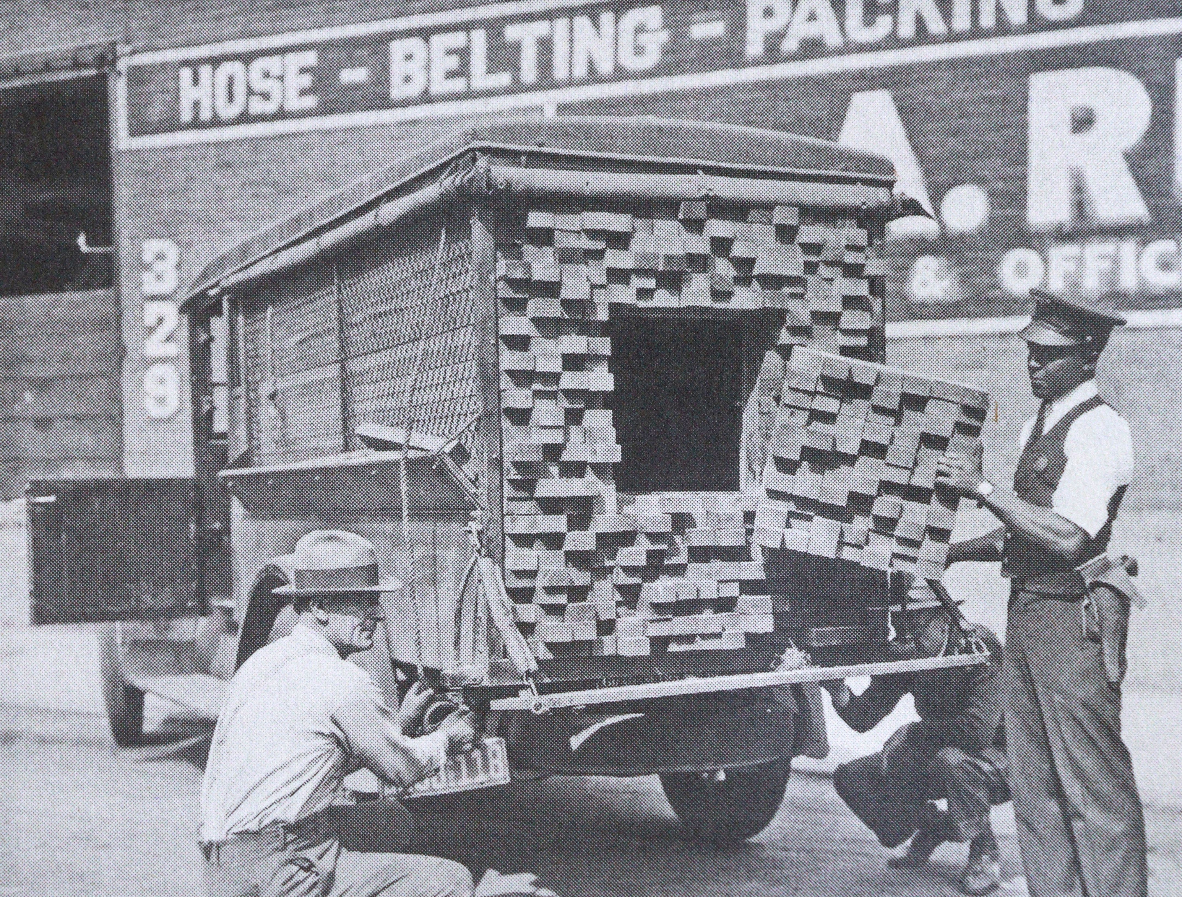 Vintage photo of police officers inspecting a truck filled with disguised contraband in brick shapes, used for smuggling purposes