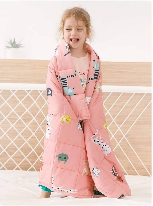 Child smiling successful animal-patterned pinkish quilted broad connected bed