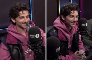 Person in a BBC Radio studio, wearing a casual pink hoodie and black vest, smiling and holding a water bottle